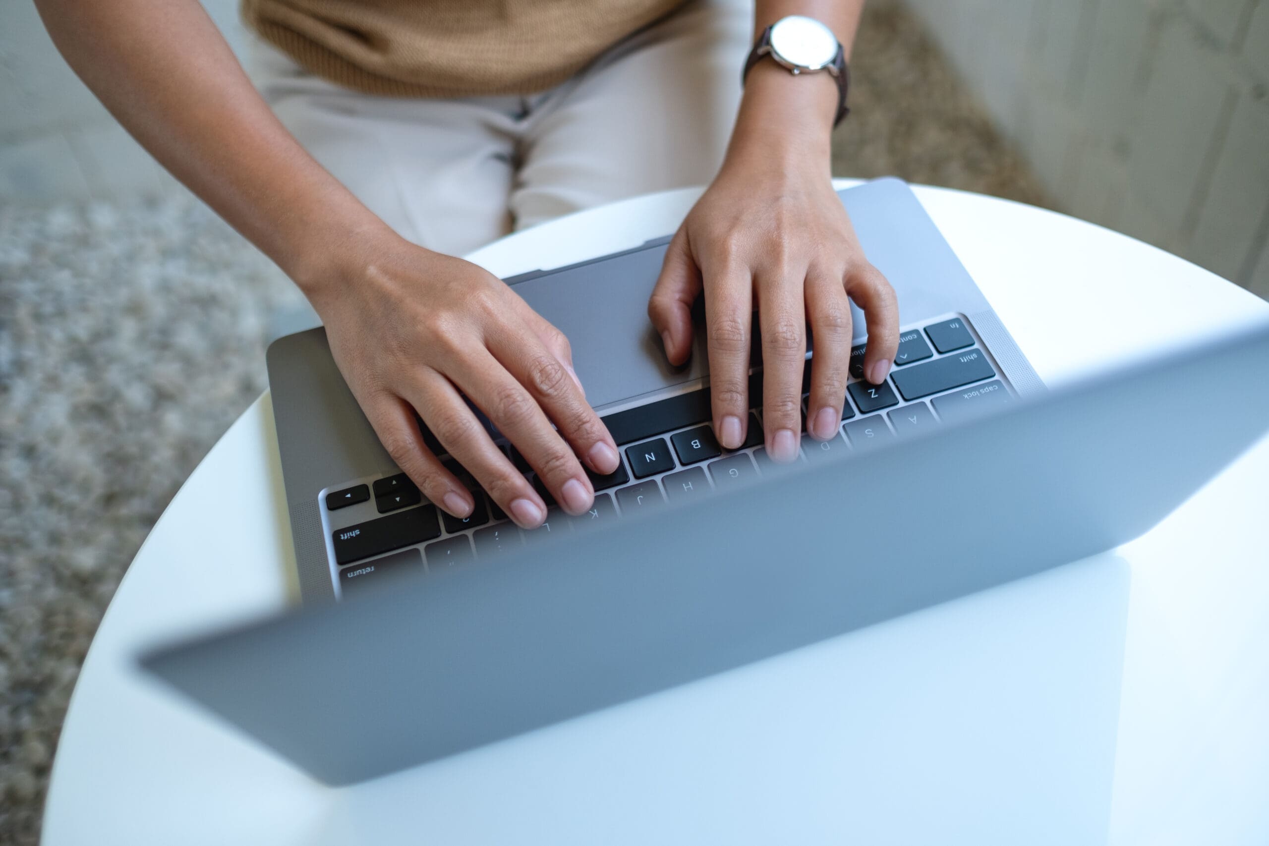 Top View Image Of A Woman Working And Typing On Laptop Computer